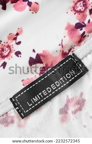 Clothing label says limited edition on satin fabric background