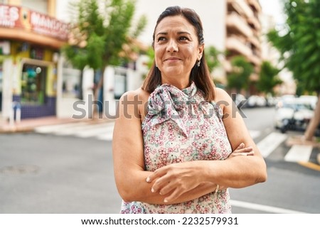 Middle age hispanic woman smiling confident standing with arms crossed gesture at street Royalty-Free Stock Photo #2232579931