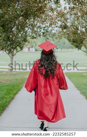 Girl from behind in a cap and gown, just graduated  Royalty-Free Stock Photo #2232585257