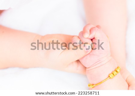 Mother holding her baby's hand