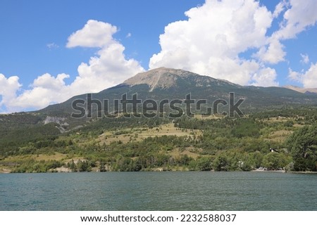 Beautiful panoramic view over a small mountain lake and a mountain in the French Alps.