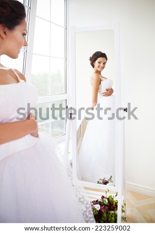 Young beautiful bride to be trying her dress in shop