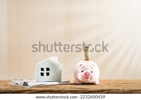 Home put on the agreement contract document and piggy bank and the gold coin is destination put on the desk in the office, Saving money for buy house or loan for investment of real estate concept.
