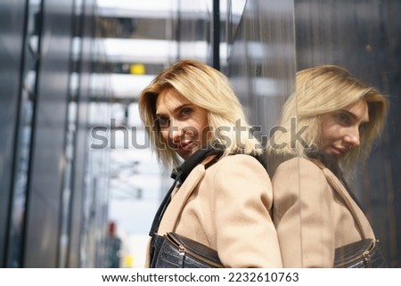 Photography of the pretty female model. Sunny spring day. Great blond. The girl coquettishly, shyly looks at camera