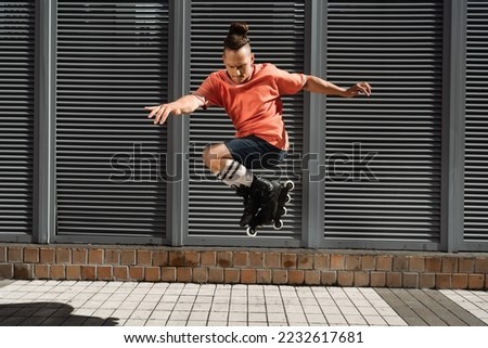 Focused man in roller blades doing trick on city street Royalty-Free Stock Photo #2232617681