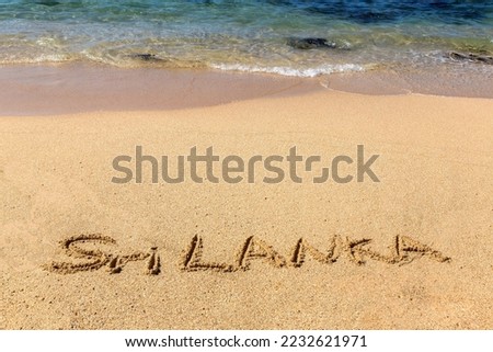 Word Sri Lanka written in a sandy on tropical beach in Sri Lanka