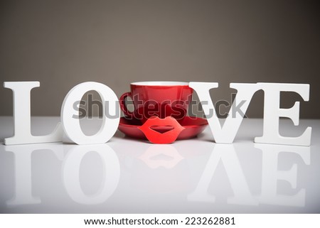 love words and red coffee cup on background