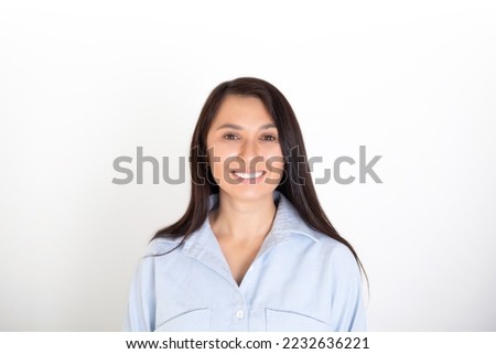 Portrait of a beautiful brunette woman in a blue shirt on a white background. Neutral makeup. Space for text. High quality photo