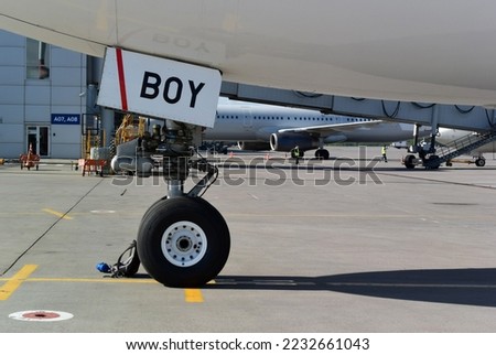 BOY sign on hatch of an aircraft. Horizontal photo with fragment of an plane at airport. Congratulations on birth of boy. Airplane travel concept. Air adventure. Chassis wheel. Air delivery. Aviation