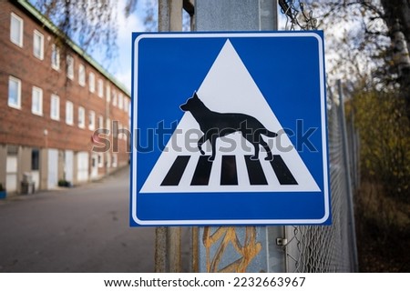 Custom dog crossing sign on a fence.