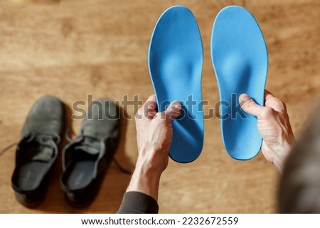 Сustom orthopedic insoles in a male hands. Man holding new cusmom insoles. Feet recreation medicine concept Royalty-Free Stock Photo #2232672559