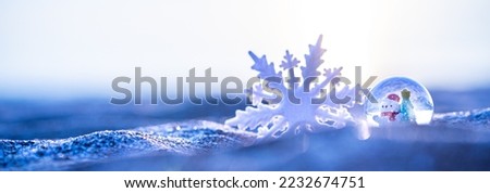 Snow globe and blurry snowflake on the sunset beach background, Christmas banner, happy concept, copy space, wide banner, Christmas banner, happy concept, copy space, soft focus