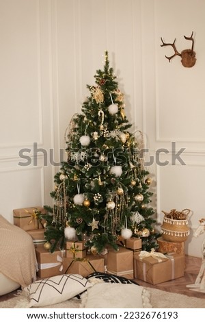 Artificial Christmas tree decorated with toys on a white background and many gifts under it
