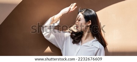Portrait of young beautiful asian woman traveler hands protect face from sun light in fresh summer time. Happy cheerful asian girl in summer. Beauty sunscreen skin care make up model concept Royalty-Free Stock Photo #2232676609
