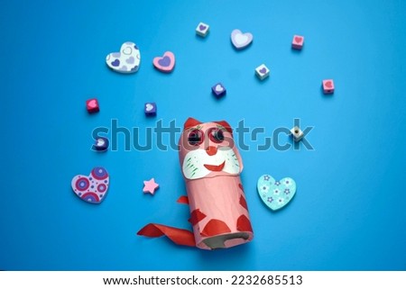 handmade craft of pink paper cat surrounded by small cute hearts