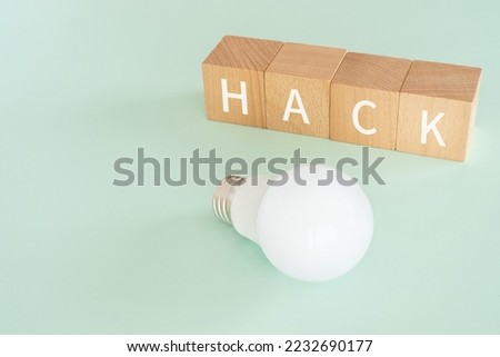 Wooden blocks with "HACK" text of concept and a lightbulb.
