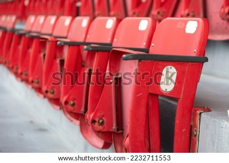 A row of red seating chair in VIP stand area at sport stadium, close-up and selective focus. Sport object background pattern photo.