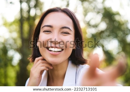 Genuine people. Portrait of asian woman laughing and smiling, walking in park, feeling joy and positivity. Royalty-Free Stock Photo #2232713101
