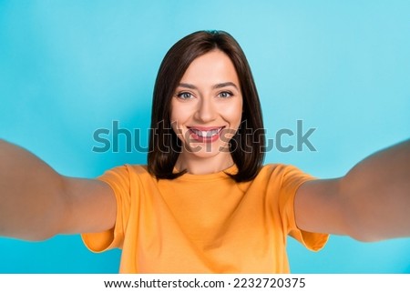 Photo of cheerful adorable person make selfie record video beaming smile isolated on blue color background