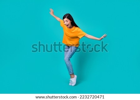 Full body photo of funky brunette lady dance look down wear t-shirt jeans boots isolated on teal color background Royalty-Free Stock Photo #2232720471