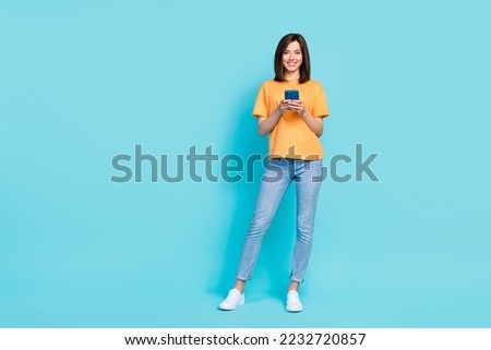 Full length photo of gorgeous cheerful person hold telephone telegram   isolated on blue color background