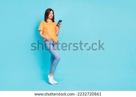 Full size portrait of positive cheerful person hold use telephone empty space isolated on blue color background