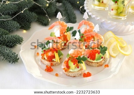 Festive canape with avocado, shrimp, avocado dip and salmon roe  for christmas or new year.