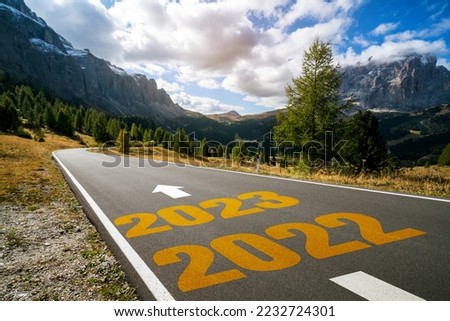 2023 New Year road trip travel and future vision concept . Nature landscape with highway road leading forward to happy new year celebration in the beginning of 2023 for fresh and successful start . Royalty-Free Stock Photo #2232724301