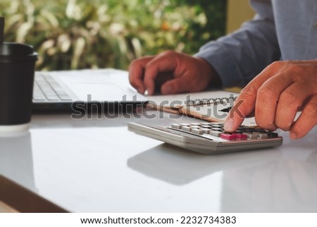 Businessmen using online personal income taxes payment calculators, and laptop computers to fill out tax refund forms. Calculation of personal and business income tax Royalty-Free Stock Photo #2232734383