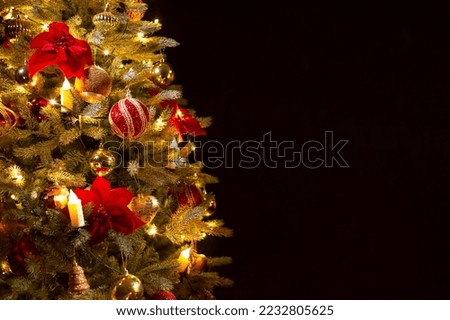 Decorated Christmas tree with lights on a dark background. Festive background for design. Selective focus, defocus