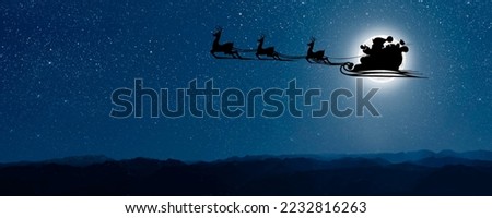 Santa Claus flies on Christmas Eve in the night sky with snow Royalty-Free Stock Photo #2232816263