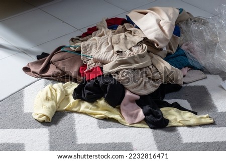 Messy mound of clothes on the floor Royalty-Free Stock Photo #2232816471