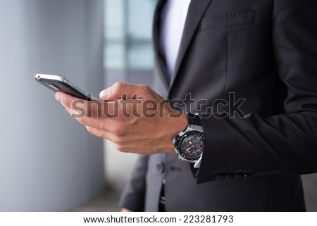 Close-up of businessman hands and smartphone Royalty-Free Stock Photo #223281793