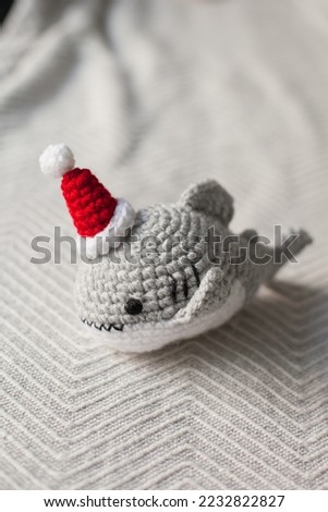 Crocheted plush shark in Santa hats as Christmas gifts.  Amigurumi toys handmade. Crochet hobby. Making DIY gifts for family and friends and kids. 
