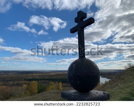 metal orthodox cross on a background of blue sky with white clouds