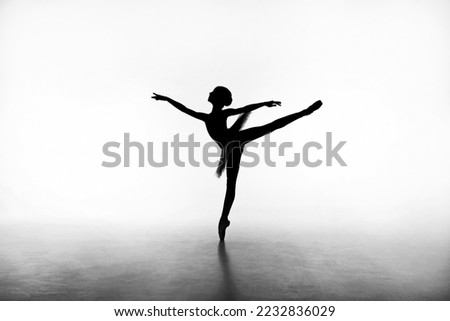 Young beautiful ballerina in a blacklight. Silhouette in white background. Art, motion, action, inspiration concept.	Arabesque
