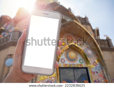 Close up women using a smartphone with an empty white screen at the historic temple landmark of Phetchabun in Thailand. Travel destination advertising concept