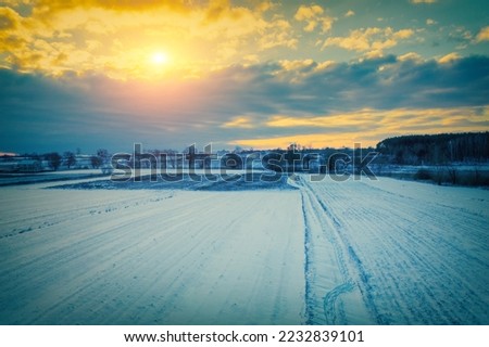 Beautiful winter sunrise in the snowy field