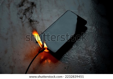 connected to charger in socket. never charge battery overnight, there is risk of battery catching fire, unattended transformer. skin burns when saving property, disconnecting from electric source Royalty-Free Stock Photo #2232839451