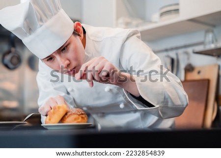 A pastry chef who creates sweets with special attention to detail Royalty-Free Stock Photo #2232854839