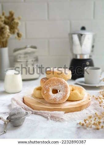 Selective focus of donuts covered in powdered sugar with coffee. White background  Royalty-Free Stock Photo #2232890387