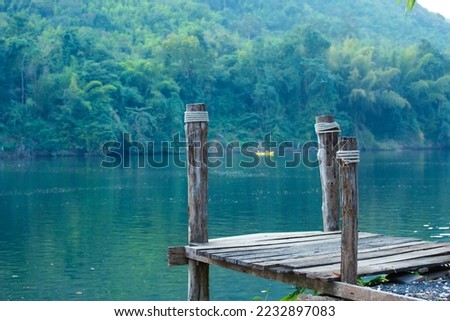Resting place it is a view of the river and mountain covered with green tree. which place to relax and unwind in good weather  in Kanchanaburi ,Thailand.   Royalty-Free Stock Photo #2232897083