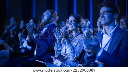 Young Female Sitting in a Crowded Audience at a Science Conference. Delegate Cheering and Applauding After an Inspirational Keynote Speech. Auditorium with Young Successful Specialist. Royalty-Free Stock Photo #2232908089
