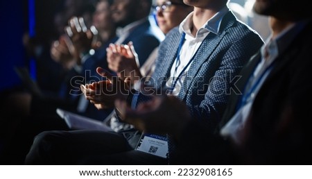 Close Up on Hands of a Crowd of People Clapping in Dark Conference Hall During a Motivational Keynote Presentation. Business Technology Summit Auditorium Room Full of Delegates. Royalty-Free Stock Photo #2232908165
