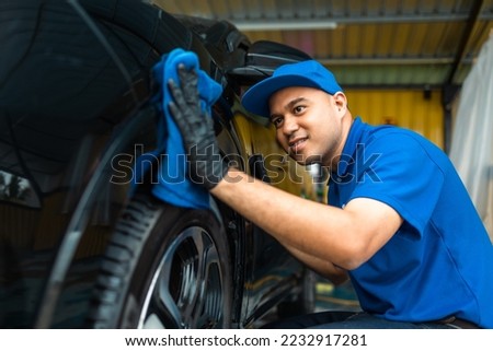 Man worker washing car service with micro fiber. Car wash cleaning wipe station. Employees clean a vehicle professionally detailing. Royalty-Free Stock Photo #2232917281