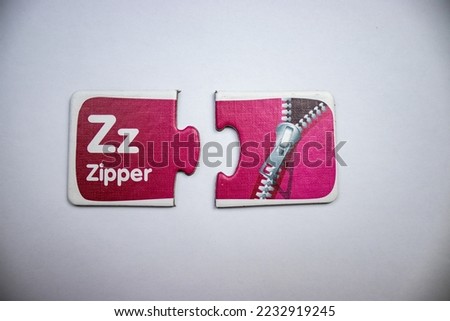 Flashcard in the form of a split puzzle with the letter z and a gray zipper placed on a white background
