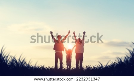 Silhouette of little girl and parents  looking at the sun. Family love. Togetherness.