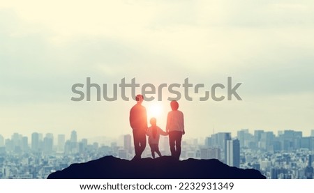 Silhouette of a family looking at the city from the top of a mountain. Family love. Togetherness.