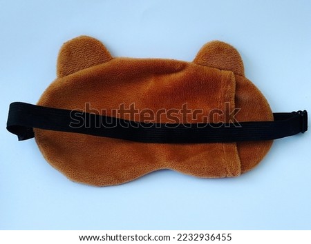 Blindfold or sleep mask with cute brown shape, photo taken from top angle
