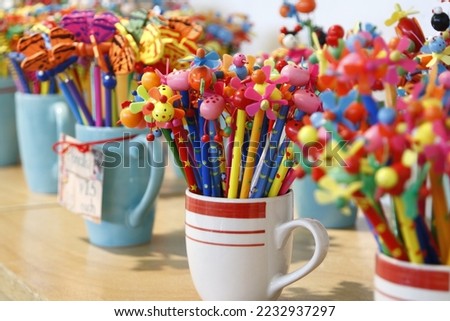 Colorful children's pencils with cute plastic cartoon decorations on top